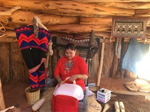 Navajo lady below spins raw wool